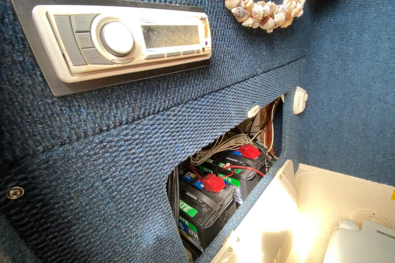 Slide: The Image of 2005 Grady-White Advance 257 boat interior with stereo and battery compartment. - 82