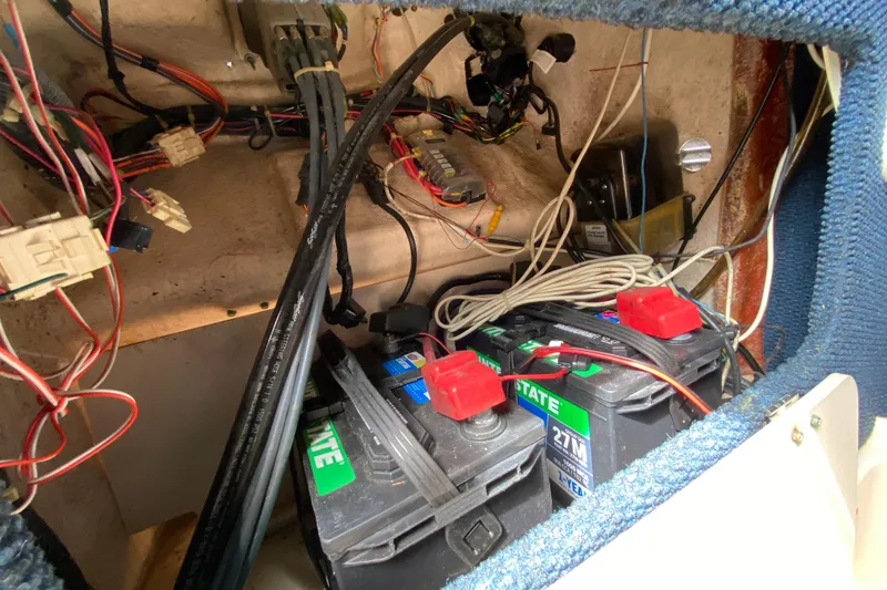 Slide: The Image of 2005 Grady-White Advance 257 boat battery compartment with wiring and components. - 83