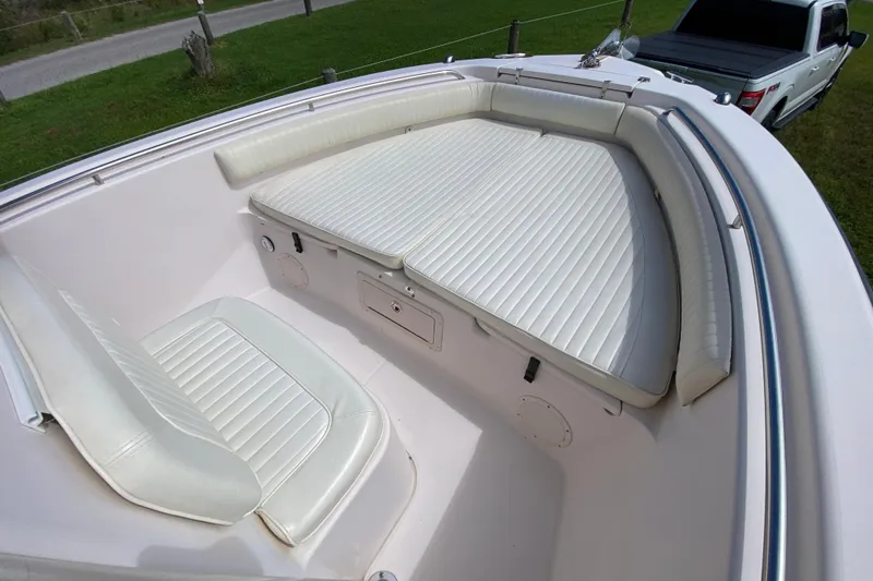 Slide: The Image of 2005 Grady-White Advance 257 boat with white cushioned seating and a pickup truck nearby. - 85