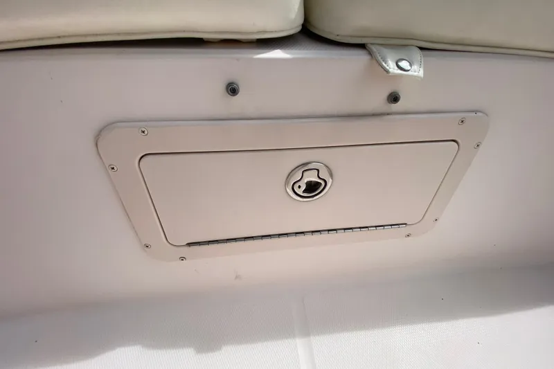 Slide: The Image of Storage compartment on a 2005 Grady-White Advance 257 boat, featuring a secure latch. - 93