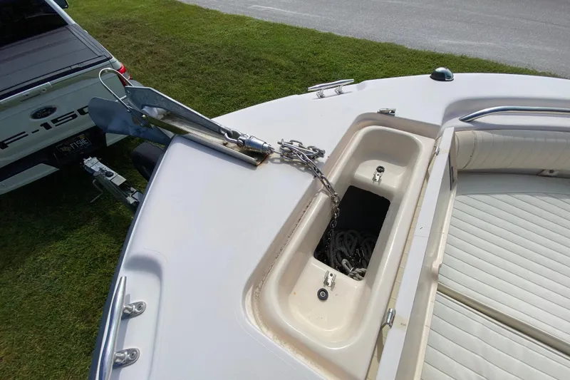 Slide: The Image of 2005 Grady-White Advance 257 boat with anchor and chain storage, parked near a Ford F-150. - 98