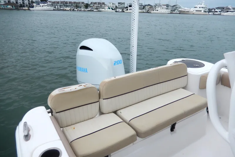 Slide: The Image of 2018 Sea Fox 226 Commander boat interior with beige seating and steering wheel on calm water. - 13