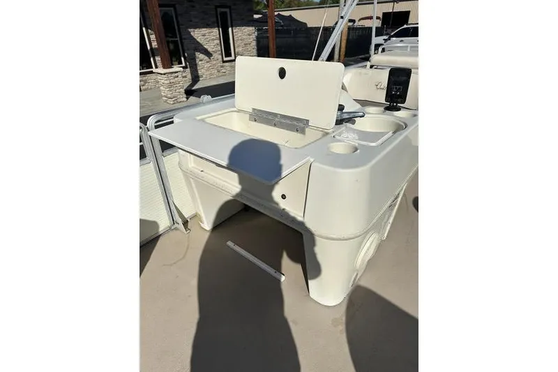 Slide: The Image of 1997 Harris 240 boat interior with open storage compartment and cup holders. - 16