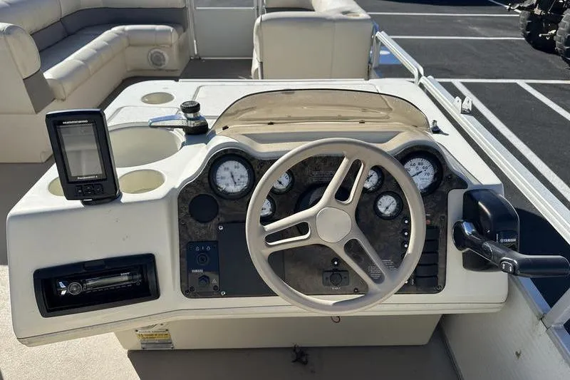 Slide: The Image of 1997 Harris 240 boat dashboard with steering wheel, gauges, and navigation equipment. - 21