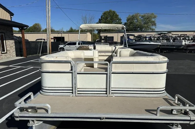 Slide: The Image of 1997 Harris 240 pontoon boat with white seating, parked outdoors on a sunny day. - 5