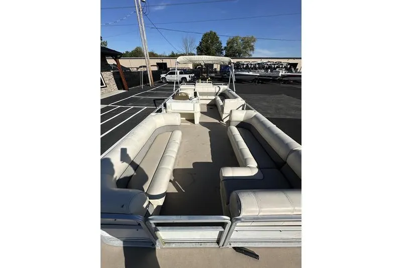 Slide: The Image of 1997 Harris 240 pontoon boat with spacious seating, parked outdoors under clear skies. - 8