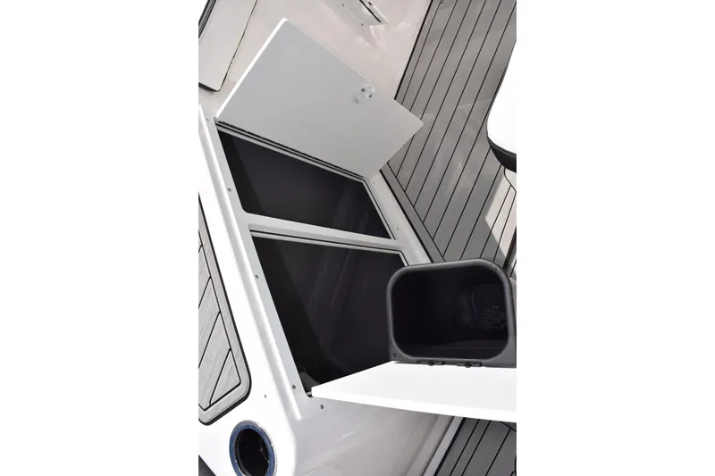 Slide: The Image of 2026 Yamaha Boats 222 FSH Sport E storage compartment with open hatch and sleek design. - 16