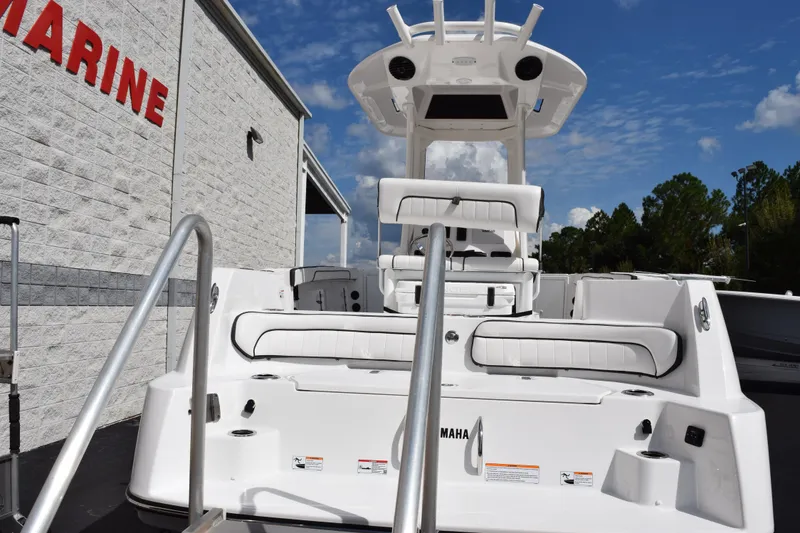 Slide: The Image of 2026 Yamaha Boats 222 FSH Sport E, white interior, docked near marine building. - 5