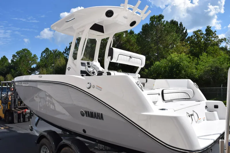 Slide: The Image of 2026 Yamaha Boats 222 FSH Sport E, sleek white design, parked outdoors under blue sky. - 6