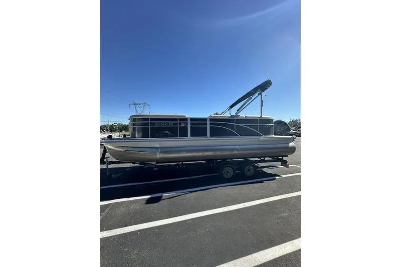 Slide: The Image of 2019 Bennington 22 SSRCX pontoon boat on trailer under clear blue sky. - 6