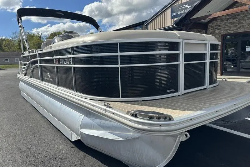 Slide: The Image of 2016 Bennington 2250 GSR pontoon boat parked outdoors under a partly cloudy sky. - 23