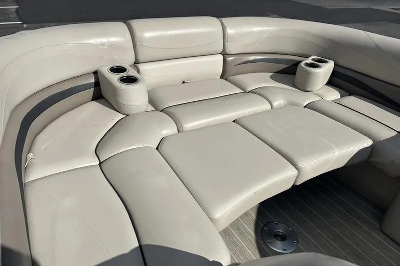Slide: The Image of 2016 Bennington 2250 GSR boat interior with beige cushioned seating and cup holders. - 9