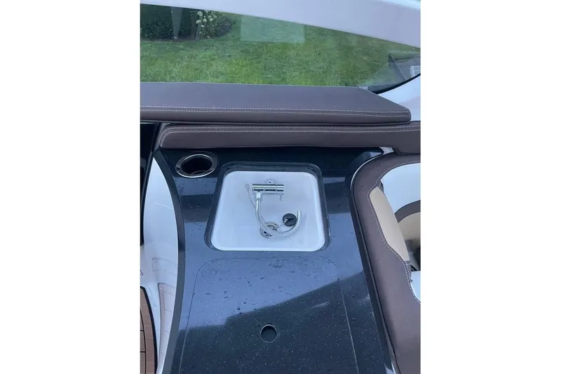 Slide: The Image of 2021 Yamaha Boats 275SD interior with sink and cup holder on deck. - 13