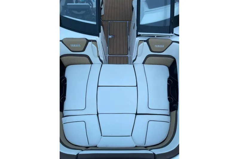 Slide: The Image of 2021 Yamaha Boats 275SD interior with white cushioned seating and teak flooring. - 5