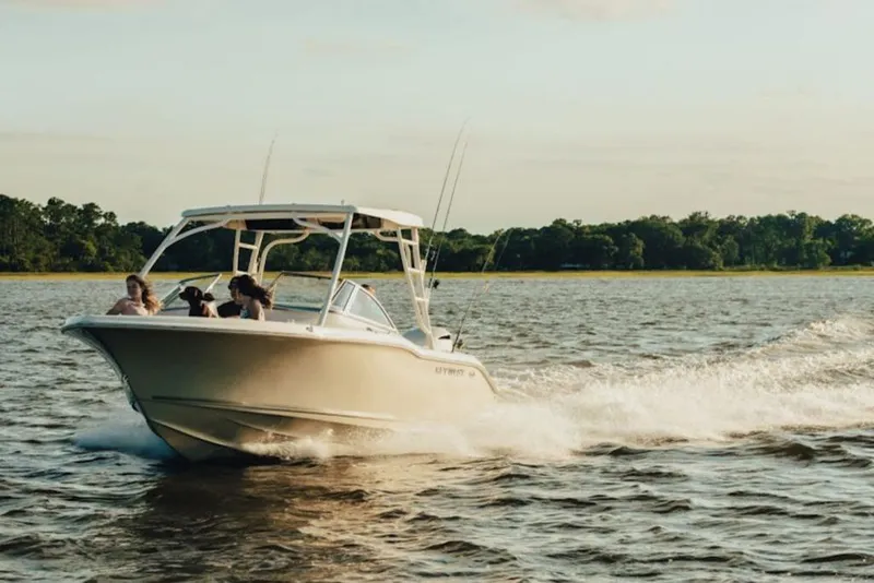 The Image of 2026 Key West 239 FS boat cruising on a scenic lake with passengers enjoying the ride. - 2