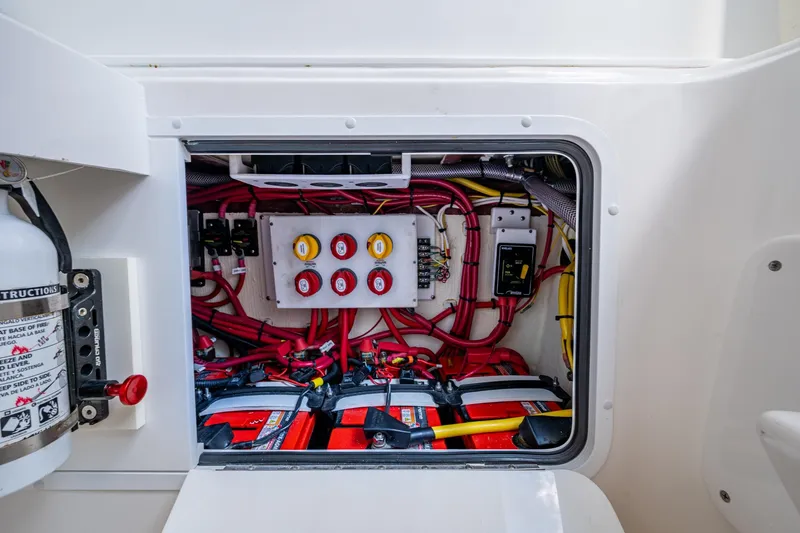 Slide: The Image of Electrical compartment of 2023 Invincible 36 Open Fisherman boat, featuring wiring and battery setup. - 17