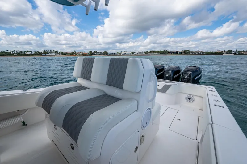 Slide: The Image of 2023 Invincible 36 Open Fisherman boat with cushioned seating and powerful engines on the water. - 55