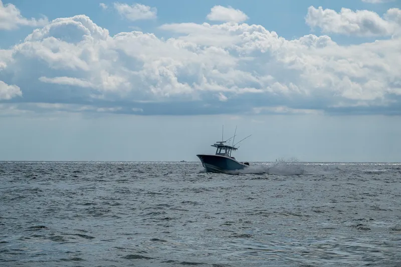 Slide: The Image of 2023 Invincible 36 Open Fisherman boat cruising on open sea under cloudy sky. - 68