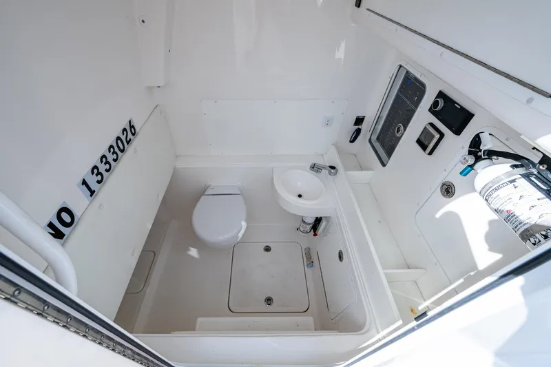 Slide: The Image of 2023 Invincible 36 Open Fisherman boat interior with toilet, sink, and control panel. - 73