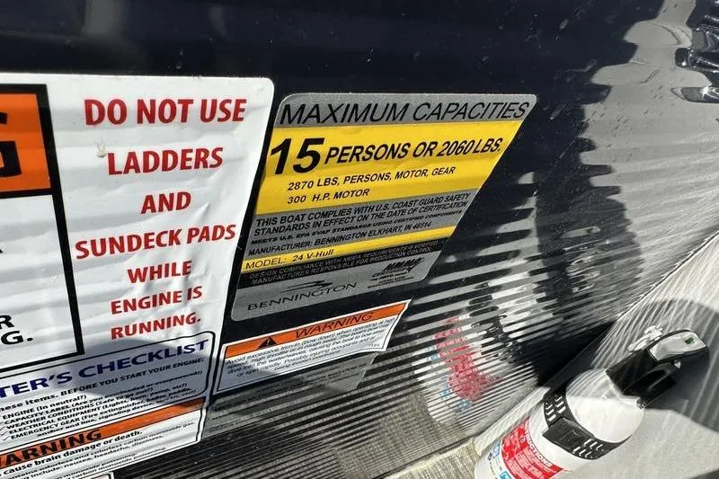 Slide: The Image of Bennington 24 RTFB 2021 boat capacity label, warning signs, and fire extinguisher. - 17