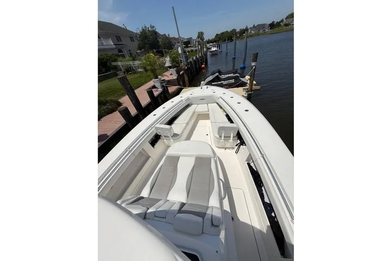 Slide: The Image of 2018 Invincible 42 Open Fisherman boat docked by waterfront homes. - 10