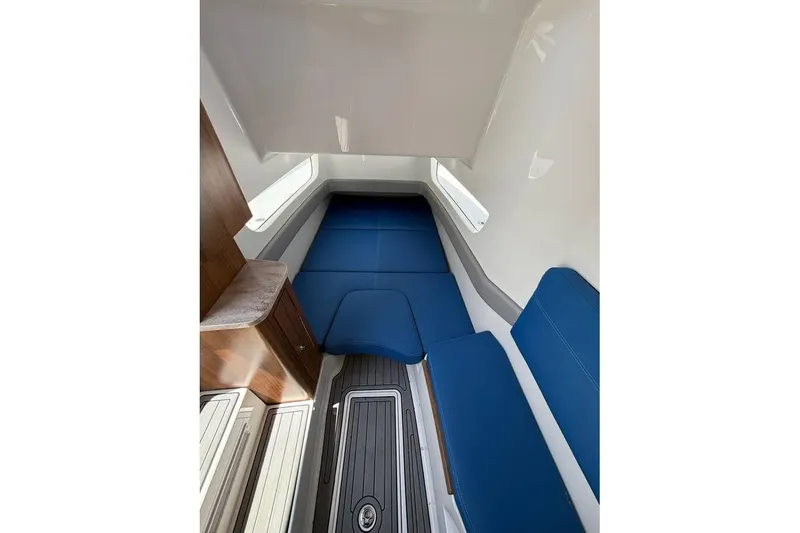 Slide: The Image of 2018 Invincible 42 Open Fisherman cabin with blue seating and wood accents. - 17