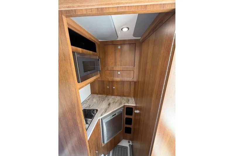 Slide: The Image of 2018 Invincible 42 Open Fisherman cabin interior with wood finish and modern appliances. - 20