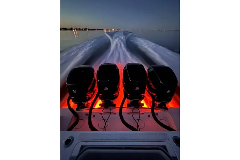 Slide: The Image of 2018 Invincible 42 Open Fisherman with four illuminated outboard engines at dusk. - 22