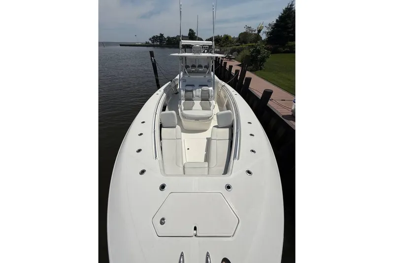 Slide: The Image of 2018 Invincible 42 Open Fisherman boat docked by a serene waterfront. - 3