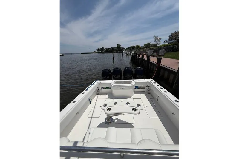 Slide: The Image of 2018 Invincible 42 Open Fisherman boat docked by a serene waterfront. - 7
