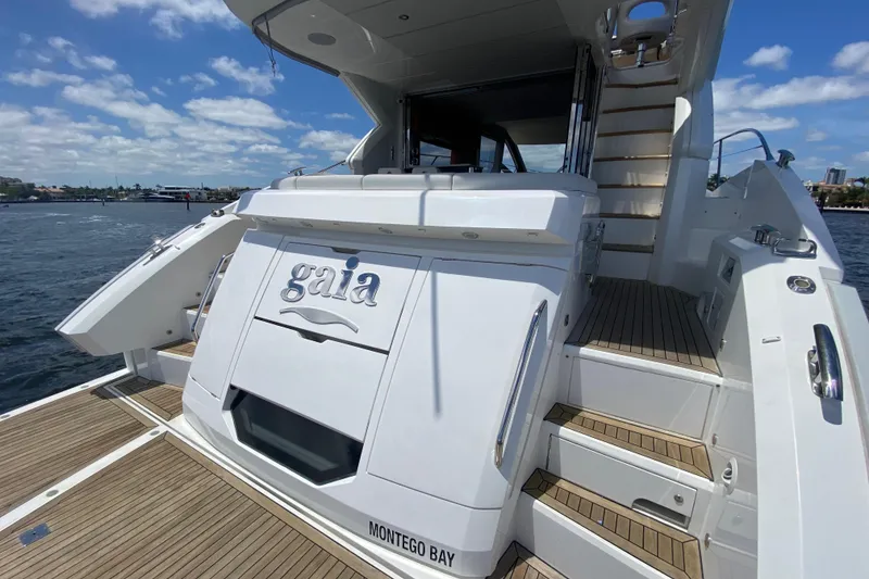 Slide: The Image of 2017 Sunseeker Manhattan 52 yacht, rear view, docked with wooden deck and stairs. - 13