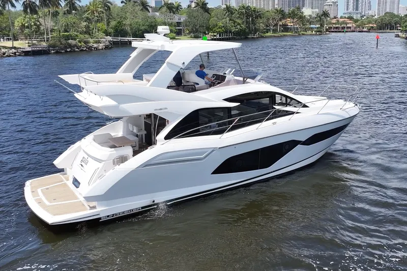 Slide: The Image of 2017 Sunseeker Manhattan 52 yacht cruising on a scenic waterway. - 2