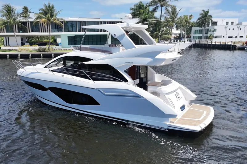 Slide: The Image of 2017 Sunseeker Manhattan 52 yacht cruising near modern waterfront homes. - 3