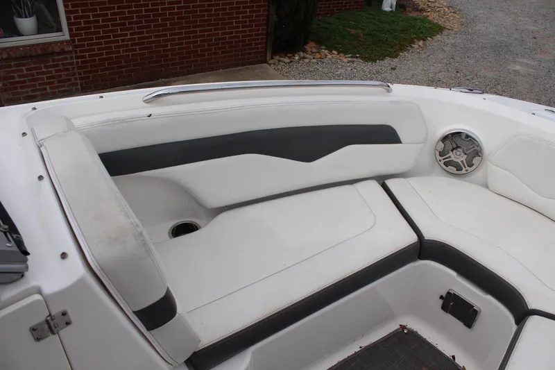 Slide: The Image of 2015 Chaparral 226 SSi boat interior with white and gray seating, speaker, and cup holder. - 10