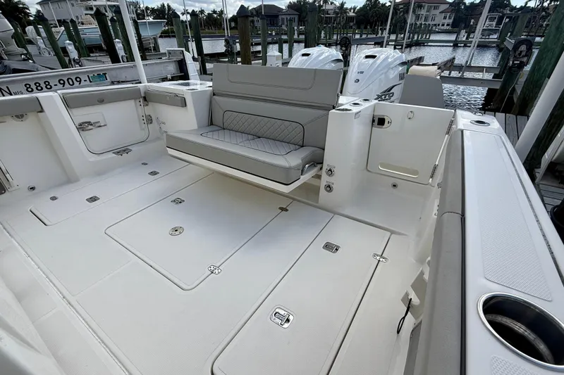 Slide: The Image of 2023 Pursuit S 358 Sport boat interior with seating and storage, docked at marina. - 15