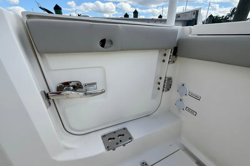 Slide: The Image of 2023 Pursuit S 358 Sport boat interior, featuring a door with handle and water access points. - 17