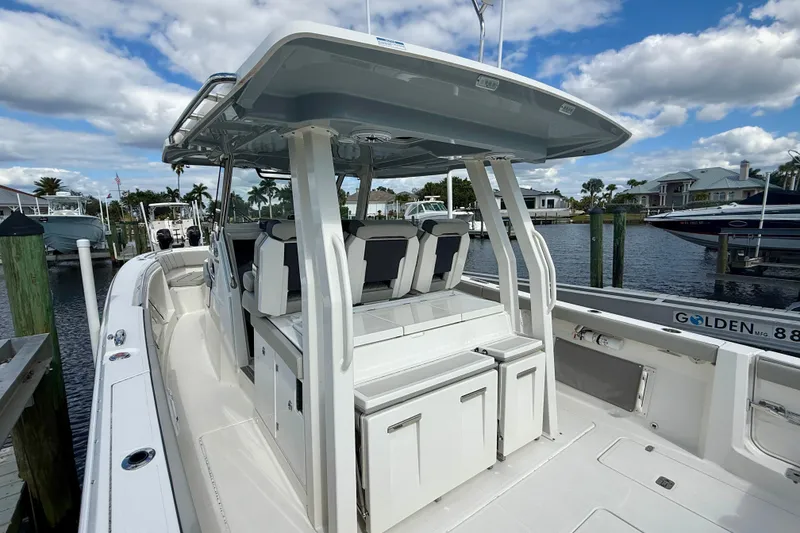 Slide: The Image of 2023 Pursuit S 358 Sport boat docked, featuring sleek design and spacious seating. - 23
