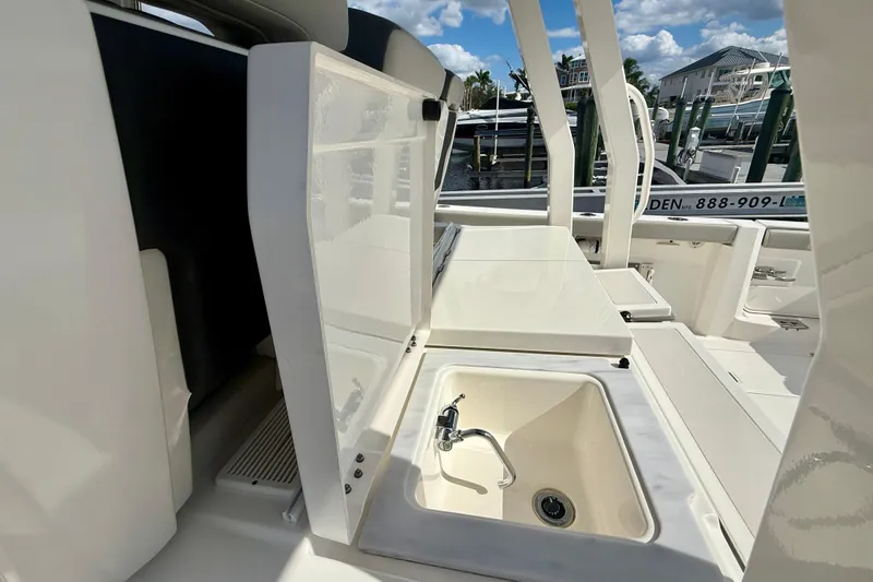 Slide: The Image of 2023 Pursuit S 358 Sport boat interior with sink and storage compartments. - 28