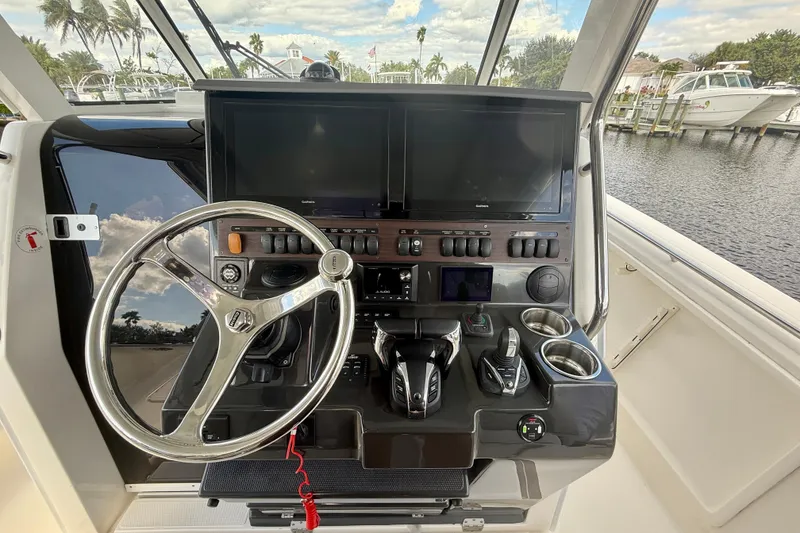Slide: The Image of 2023 Pursuit S 358 Sport boat helm with steering wheel and control panel. - 38