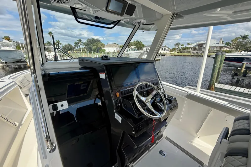 Slide: The Image of 2023 Pursuit S 358 Sport boat helm with modern controls and waterfront view. - 43