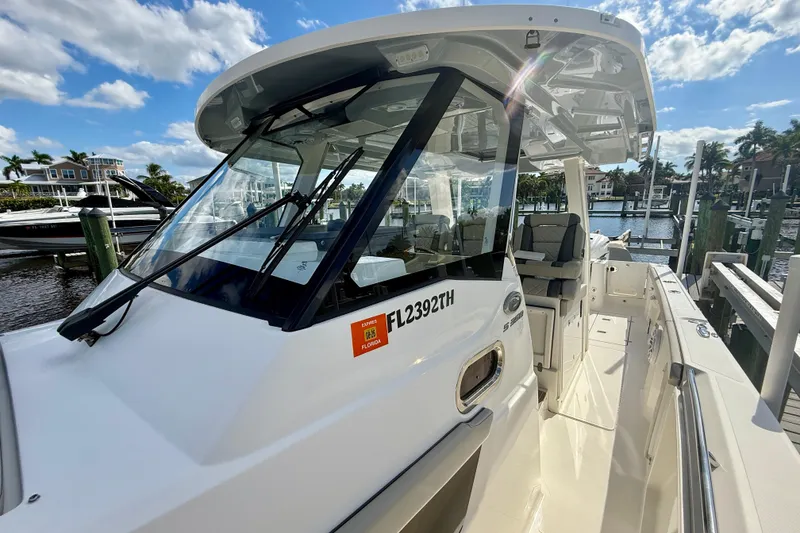 Slide: The Image of 2023 Pursuit S 358 Sport boat docked under a sunny sky. - 44