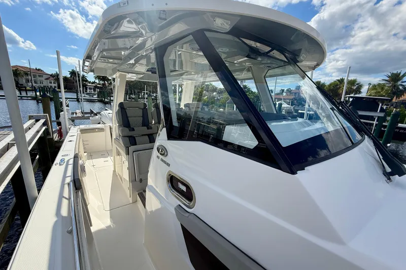 Slide: The Image of 2023 Pursuit S 358 Sport boat docked, showcasing sleek design and spacious seating. - 46