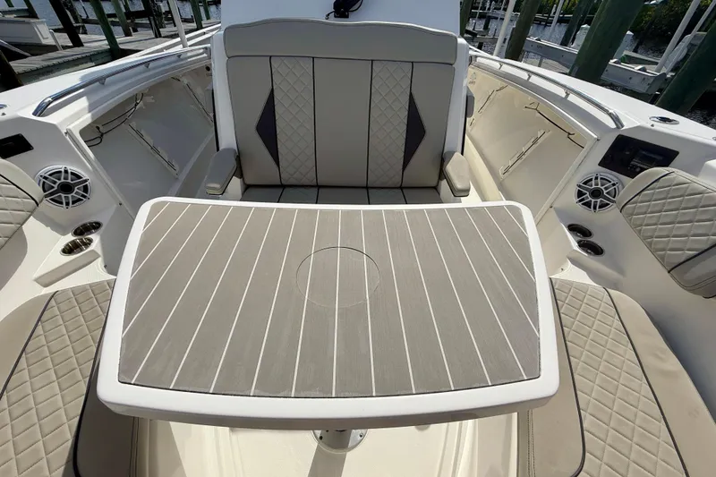 Slide: The Image of 2023 Pursuit S 358 Sport boat interior with cushioned seating and table. - 56