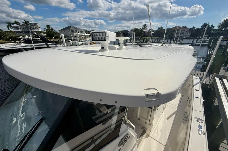 Slide: The Image of 2023 Pursuit S 358 Sport boat docked under a partly cloudy sky. - 57