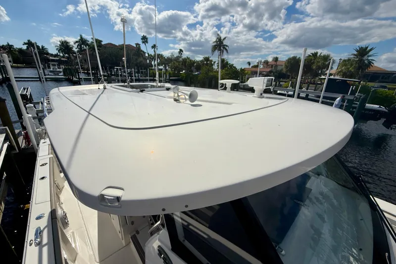 Slide: The Image of 2023 Pursuit S 358 Sport boat docked under a sunny sky with palm trees. - 58