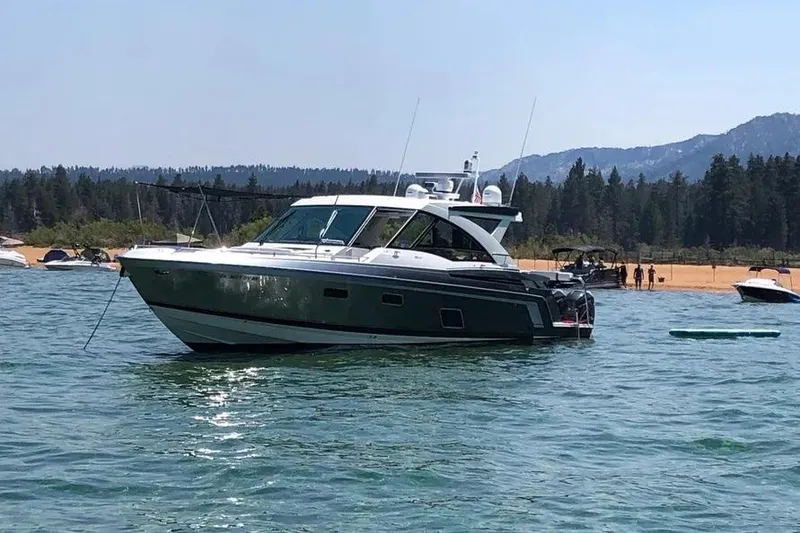 The Image of 2019 Formula 430 Super Sport Crossover boat on a scenic lake with forested mountains. - 1