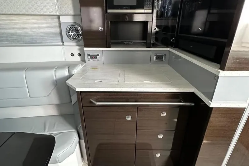 Slide: The Image of 2019 Formula 430 Super Sport Crossover interior with modern kitchenette and sleek cabinetry. - 7