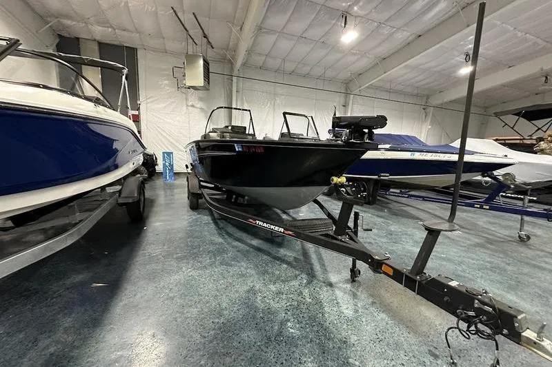 Slide: The Image of 2022 Tracker Targa V-19 Combo boat interior with seating and motor in a showroom. - 10