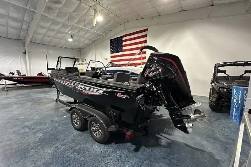 Slide: The Image of 2022 Tracker Targa V-19 Combo boat interior with seating and motor in a showroom. - 4