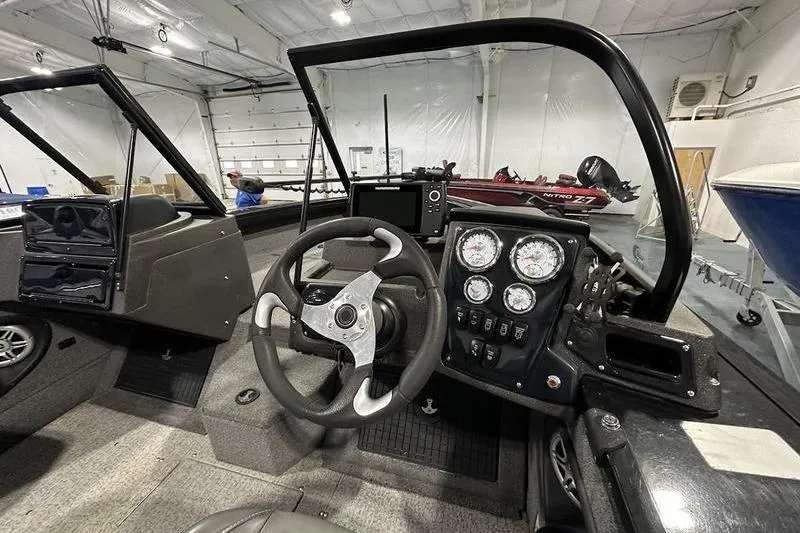 Slide: The Image of 2022 Tracker Targa V-19 Combo boat in showroom with American flag backdrop. - 9